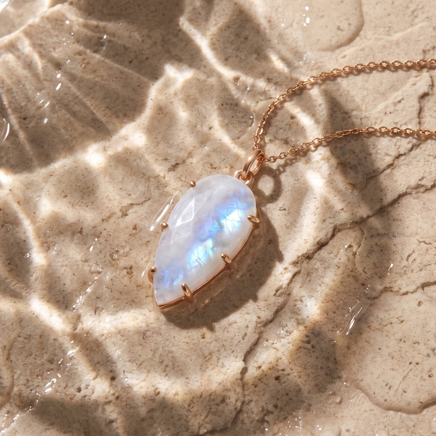 Moonstone gemstone pendant necklace still life on beige stone